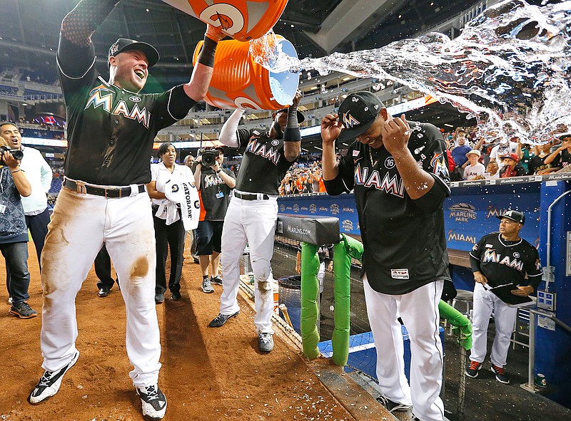 Miami Marlins' Justin Bour, left, and Marcell Ozuna, center rear, pour ice and water onto starting pitcher Edinson Volquez, right, after the Marlins defeated the Arizona Diamondbacks 3-0 in a no-hitter by Volquez during a baseball game, Saturday, June 3, 2017, in Miami. 