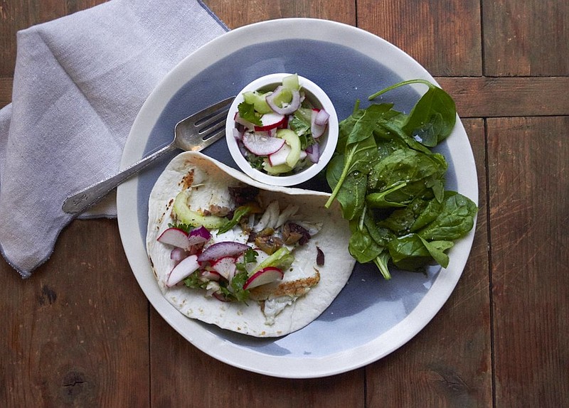 This 2016 photo shows flaky fish tacos in New York. This dish is from a recipe by Katie Workman. 