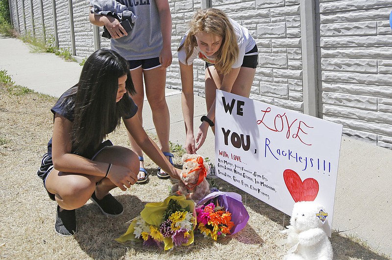 People leave items at a memorial for the victims of a fatal shooting Wednesday, June 7, 2017, in Sandy, Utah. Utah investigators and residents of a middle-class Salt Lake City suburb were trying Wednesday to understand what led a man to open fire on a woman and children inside a car leaving the woman and one of her sons dead, another son in critical condition and a girl injured. The suspect was found dead of a self-inflicted gunshot wound at the scene in a quiet neighborhood of the city of Sandy. 