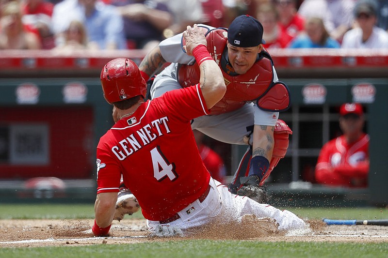 Cincinnati Reds' Scooter Gennett (4) is tagged out at home by St. Louis Cardinals catcher Yadier Molina in the fourth inning of a baseball game, Thursday, June 8, 2017, in Cincinnati.