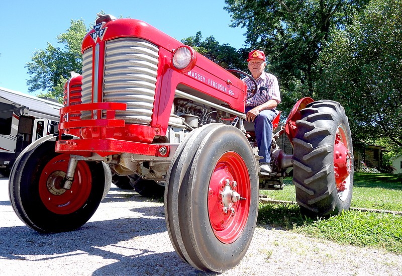 Kenny Thomas perches on one of the tractors he has refurbished over the years. He doesn't usually use this Massey-Ferguson for tractor pulls — he prefers his Massey-Harris 44 and 444 — which will be in action today at the New Bloomfield Lions Club Antique Tractor Pull.