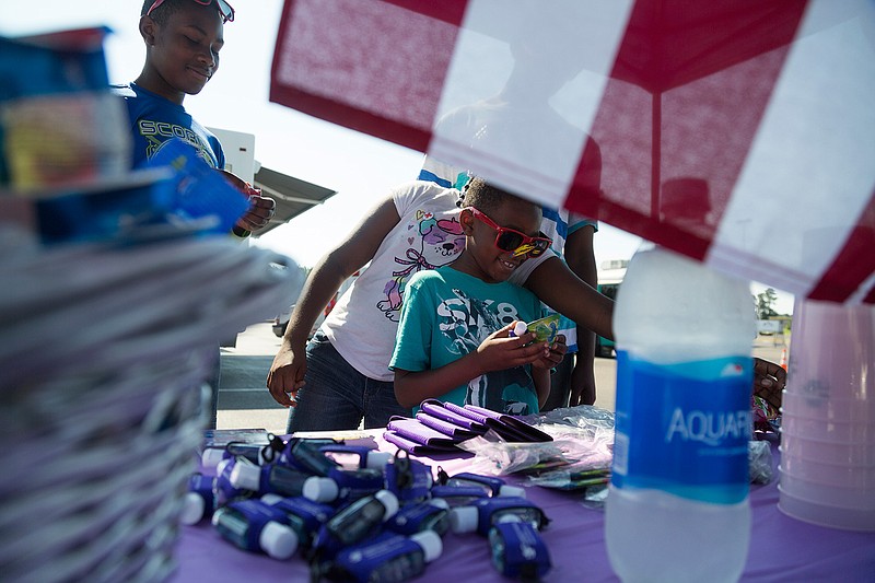 Children are given information about CHRISTUS St. Michael Health System's disaster response infrastructure and trauma center during an event Saturday at Lowe's in Texarkana, Texas. Lowe's hosted an event with area law enforcement, medical providers and emergency response organizations to inform the public and introduce citizens to first responders. 