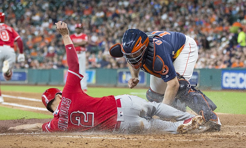 Los Angeles Angels' Andrelton Simmons (2) is tagged out by Houston Astros catcher Evan Gattis while trying to score during the fourth inning of a baseball game Sunday in Houston.