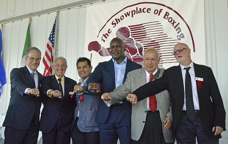 International Boxing Hall of Fame Class of 2017 inductees, from left, Steve Farhood, Barry Tompkins, Marco Antonio Barrera, Evander Holyfield, Jerry Roth and Johnny Lewis display their rings following the induction ceremony Sunday in Canastota, N.Y.