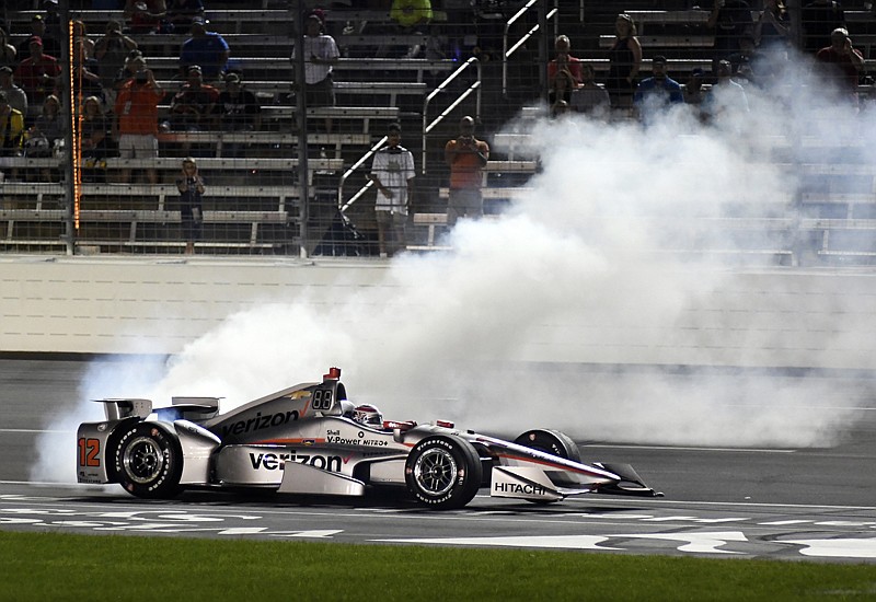 Will Power, of Australia, does doughnuts at the finish line as fans watch following his win in the IndyCar auto race Saturday at Texas Motor Speedway in Fort Worth, Texas.