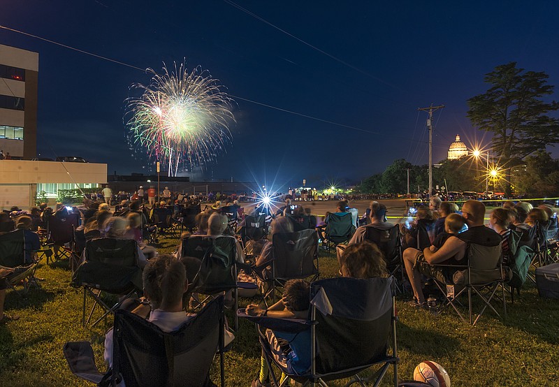 Revelers fill the Jefferson City Fire Department Station 1 lawn as colorful fireworks light the sky during the 2016 Salute to America "Red, White & Boom" fireworks display.