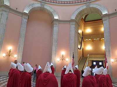 In this Tuesday, June 13, 2017 photo, women dressed in character from the dystopian novel "The Handmaid's Tale" stage a protest in the Ohio Statehouse Rotunda, in Columbus, against a bill criminalizing the state's most common abortion procedure.