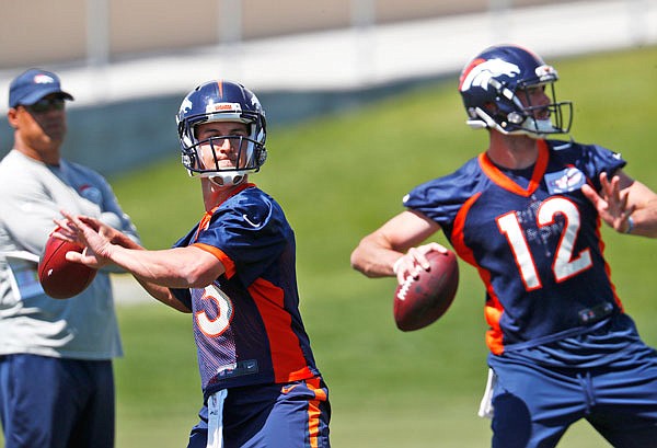 In this June 5 file photo, Broncos quarterback Trevor Siemian, left, throws along with quarterback Paxton Lynch during the team's minicamp session in Englewood, Colo.