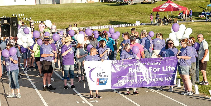 The survivors and their caregivers prepare to make a lap around the track at the Moniteau County Relay For Life on June 9, 2017.