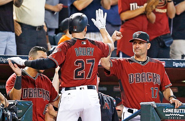 Diamondbacks second baseman Brandon Drury (center) celebrates his home run against the Brewers with manager Torey Lovullo (right) and David Peralta during the seventh inning of Sunday's game in Phoenix.