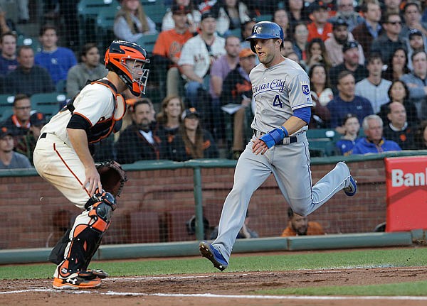 Royals left fielder Alex Gordon scores against Giants catcher Buster Posey during the third inning of Tuesday's game in San Francisco.