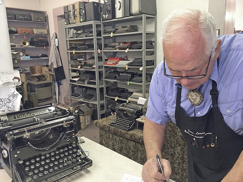 John Lewis, a typewriter repairman, works at his shop Jan. 9 in Albuquerque, N.M., in front of his collection of vintage typewriters. The vintage typewriter is making a comeback with a new generation of fans gravitating to machines that once gathered dust in attics and basements across the country.