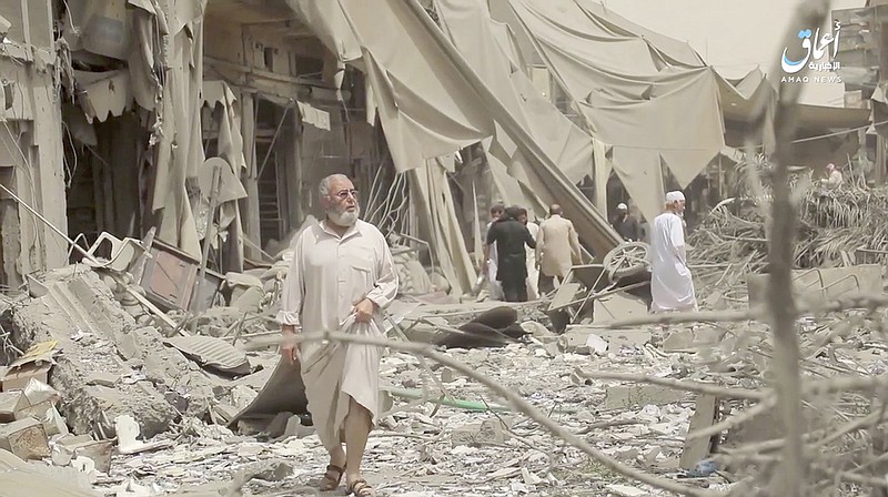 This undated file frame grab from video posted online May 29 by the Aamaq News Agency shows people inspecting damage from airstrikes and artillery shelling in the northern Syrian city of Raqqa, the de facto capital of the IS.