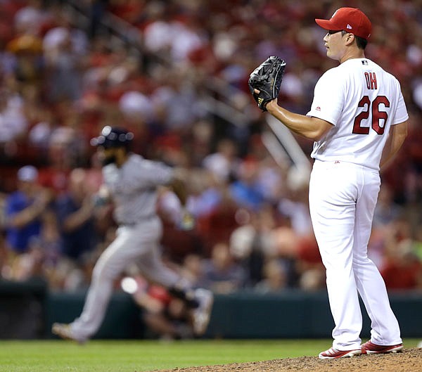 Cardinals relief pitcher Seung-Hwan Oh waits for a baseball as Eric Thames of the Brewers circles the bases after hitting a two-run home run during the ninth inning of Thursday night's game at Busch Stadium in St. Louis.