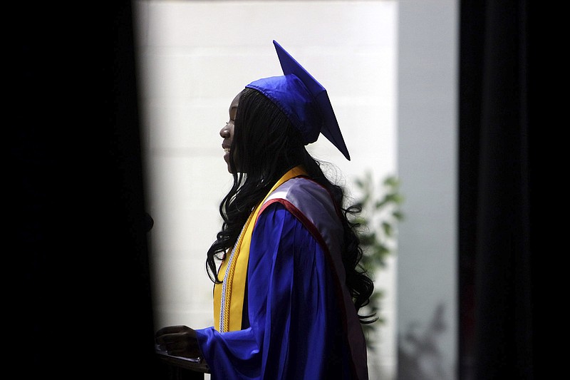 In this June 14, 2014 file photo, Carmen Stringfield introduces the valedictorian at their commencement ceremony at Pender High School in Burgaw, N.C. In a movement that has gathered steam over about the past decade, schools around the country have stopped numbering students from valedictorian on down. Instead, they've adopted honors that recognize everyone who scores at a certain threshold - by having multiple valedictorians, for example, or awarding college-style cum laude honors.