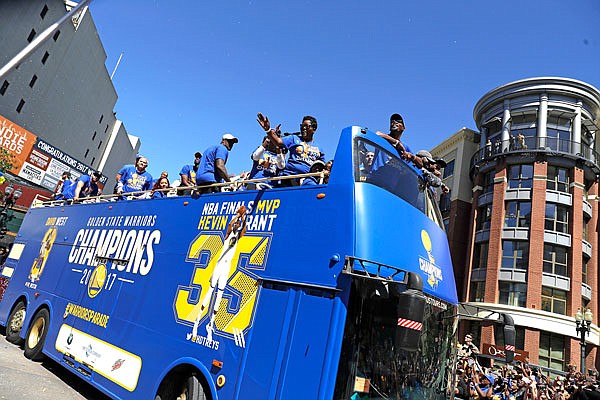 Warriors forward Kevin Durant (right) and his mother, Wanda, wave during Thursday's NBA championship parade and rally in Oakland, Calif.