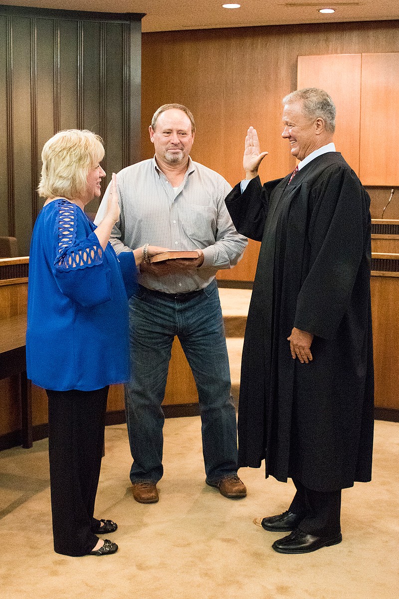 Jill Harrington places her hand on a Bible being held by her husband, Ricky Harrington, as 102nd District Judge Bobby Lockhart swears her in as Bowie County District Clerk. Harrington was appointed by the county's three district judges—Lockhart, 202nd District Judge John Tidwell and 5th District Judge Bill Miller—to fill the vacancy left when former Bowie County District Clerk Billy Fox retired effective Thursday.