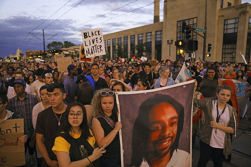 Supporters of Philando Castile hold a portrait of Castile as they march along University Avenue in St. Paul, Minn., leaving a vigil at the state Capitol on Friday, June 16, 2017. The vigil was held after St. Anthony police Officer Jeronimo Yanez was cleared of all charges in the fatal shooting last year of Castile. (Anthony Souffle/Star Tribune via AP)