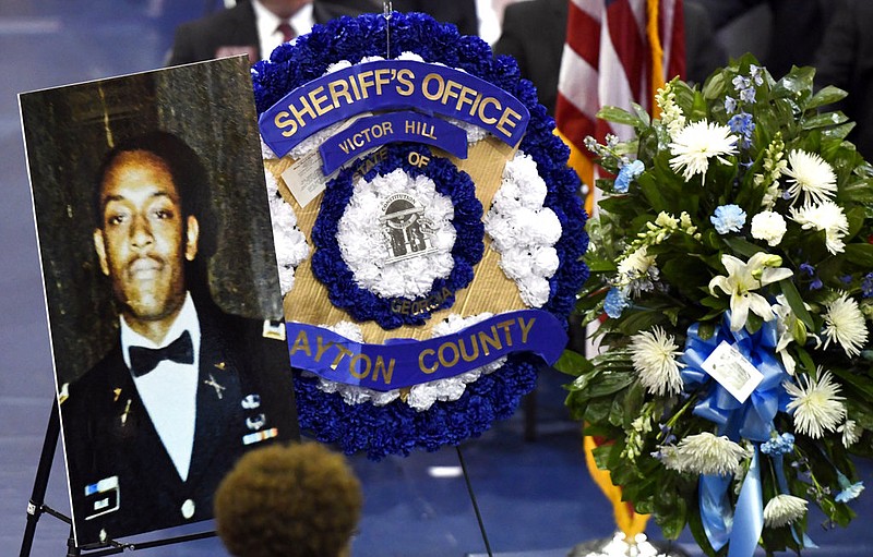 A corrections officer who was slain while transporting inmates was a hero who spent his career protecting other people, Georgia's top prison official said at the man's funeral.