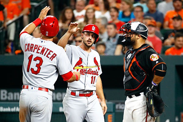 Paul DeJong greets Cardinals teammate Matt Carpenter after scoring on Carpenter's home run in the sixth inning of Friday night's game against the Orioles in Baltimore.