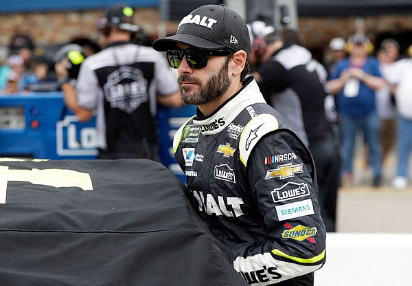 Jimmie Johnson enters his car during qualifying Friday in Brooklyn, Mich. Johnson has agreeed to a three-year contract extension with Hendrick Motorsports.