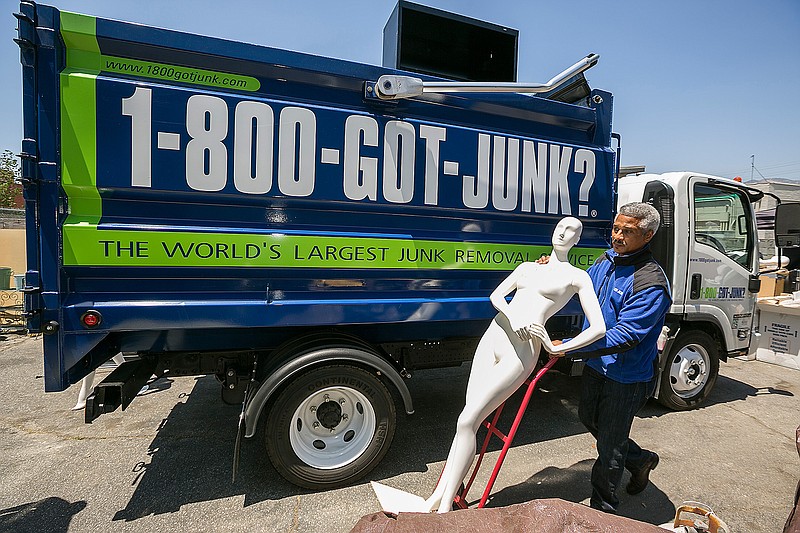 In this Friday, Jun. 9, 2017, photo, 1-800-GOT-JUNK? business owner James Williams gets ready to load a store mannequin into a truck at the business, in Burbank, Calif. Removing the contents of a store is just one part of the job, says Williams. His company also donates usable equipment like vacuum cleaners to charities and takes furniture and fixtures to businesses that will recycle everything that's usable. Williams estimates that he's handled about two store closings a year during the nearly 12 years he's owned the franchise. But there's also a downside for his business when a store closes...he's just lost a customer. 