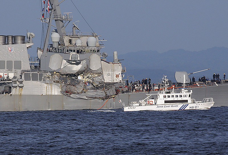 A Japan Coast Guard ship, foreground, navigates the damaged USS Fitzgerald near the U.S. Naval base in Yokosuka, southwest of Tokyo, after the U.S. destroyer collided with the Philippine-registered container ship ACX Crystal in the waters off the Izu Peninsula Saturday, June 17, 2017. The USS Fitzgerald was back at its home port in Japan after colliding before dawn Saturday with a container ship four times its size, while the coast guard and Japanese and U.S. military searched for seven sailors missing after the crash.