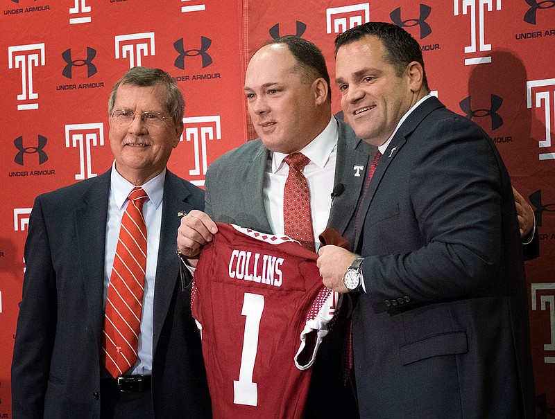 In this Dec. 14, 2016, file photo, Geoff Collins, center, stands between Temple University president Richard Englert, left, and athletic director Pat Kraft, during an NCAA college football news conference in Philadelphia, where Collins was introduced as Temple's new head football coach. Collins, former Florida defensive coordinator, has brought swag and Nick Saban structure to Temple. 