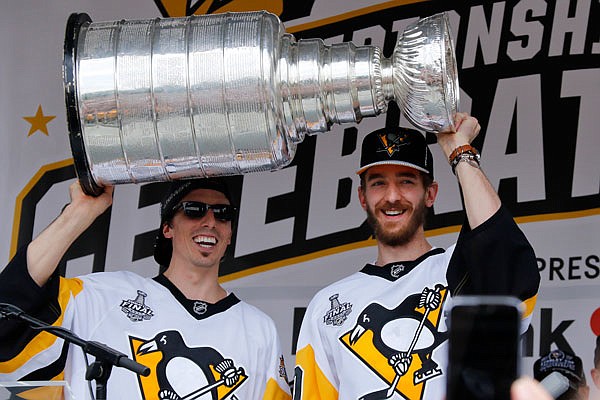 Penguins goalies Marc-Andre Fleury (left) and Matt Murray hold the Stanley Cup on stage last Wednesday after riding in the victory parade in Pittsburgh. The Penguins protected Murray and not Fleury in the upcoming expansion draft.