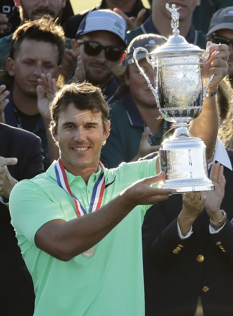 Brooks Koepka holds up the winning trophy after the U.S. Open golf tournament Sunday, June 18, 2017, at Erin Hills in Erin, Wis. 