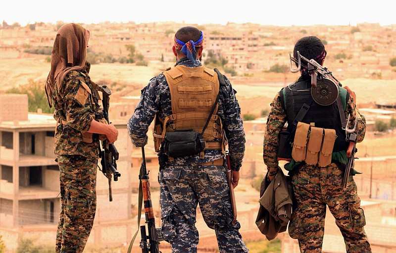 This April 30, 2017, file photo provided by the Syrian Democratic Forces (SDF) shows fighters from the SDF looking toward the northern town of Tabqa, Syria. The U.S.-led coalition headquarters in Iraq said in a written statement that a U.S. F-18 Super Hornet shot down a Syrian government SU-22 on Sunday, June 18, after it dropped bombs near the U.S. partner forces, known as the Syrian Democratic Forces. The shootdown was near the Syrian town of Tabqa. 