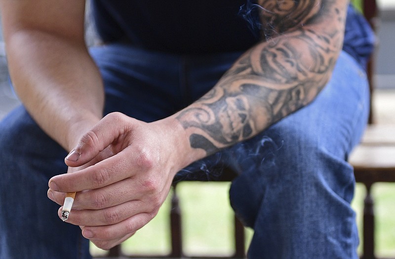 Paul Wright smokes a cigarette, Thursday, June 15, 2017, at the Neil Kennedy Recovery Clinic in Youngstown, Ohio. Republican efforts to roll back “Obamacare” are colliding with the opioid epidemic. Cutbacks would hit hard in states that are deeply affected by the addiction crisis and struggling to turn the corner. The issue is Medicaid, expanded under former President Barack Obama. Data show that Medicaid expansion is paying for a large share of treatment costs in hard hit states.  (AP Photo/David Dermer)