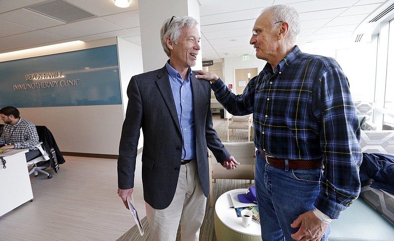 In this photo taken March 29, 2017, Dr. David Maloney of the Fred Hutchinson Cancer Research Center is greeted by patient Ken Shefveland, whose lymphoma was successfully treated with CAR-T cell therapy. Immune therapy is the hottest trend in cancer care and its next frontier is creating "living drugs" that grow inside the body into an army that seeks and destroys tumors. 