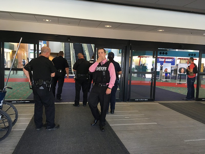 Police officers gather at a terminal at Bishop International Airport, Wednesday morning, June 21, 2017, in Flint, Mich. Officials evacuated the airport Wednesday, where a witness said he saw an officer bleeding from his neck and a knife nearby on the ground.  On Twitter, Michigan State Police say the officer is in critical condition and the FBI was leading the investigation.