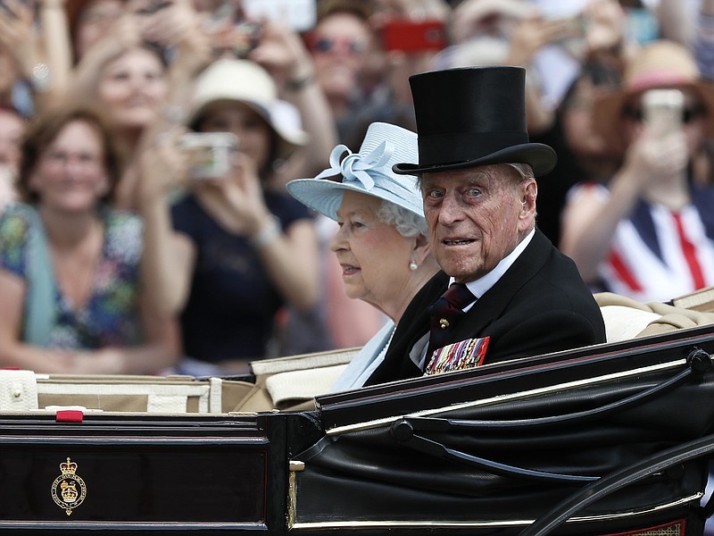 FILE - In this Saturday, June 17, 2017 file photo, Britain's Queen Elizabeth II and Prince Philip return to Buckingham Palace in a carriage, after attending the annual Trooping the Colour Ceremony in London. Buckingham Palace said on Wednesday June 21, 2017, Prince Philip is good spirits after being admitted to hospital. (AP Photo/Kirsty Wigglesworth, File)