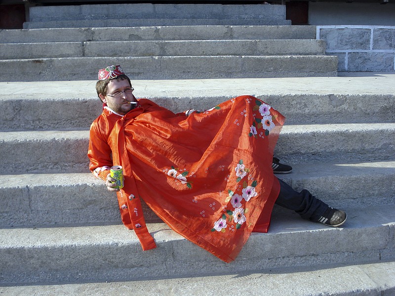 In this photo taken May 30, 2009 and released by Christopher Barbara, Gareth Johnson poses for photos while wearing a traditional costume during a visit to the Pyongyang Film Studio in Pyongyang in North Korea. British expatriate Gareth Johnson founded the Young Pioneer Tours agency in 2008 and has built up a business attracting young travelers with a competitively priced catalog of exotic-sounding, hard-partying adventures into the world's most isolated country. (Christopher Barbara via AP)
