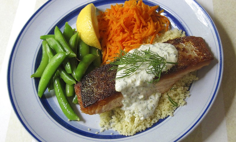 This May 30, 2017 photo shows salmon with crispy skin and pepperoncini lemon sauce in New York. This dish is from a recipe by Sara Moulton. (Sara Moulton via AP)