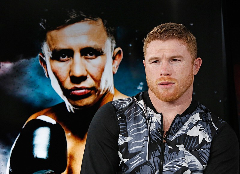 Six-time boxing title holder Saul "Canelo" Alvarez, right, of Mexico sits beside a giant photograph of upcoming opponent, IBF and WBC world middleweight champion Gennady Golovkin during an interview, Tuesday, June 20, 2017, at The Associated Press headquarters in New York. In the most anticipated superfight since Mayweather- Pacquiao, the pair will face off Sept. 16th in Las Vegas. Referring to the bout, Alvarez said, "It's gonna be a tough fight and (my team) is aware of this. But people wanted to see this fight and that's why we made it happen, to delight the fans." 