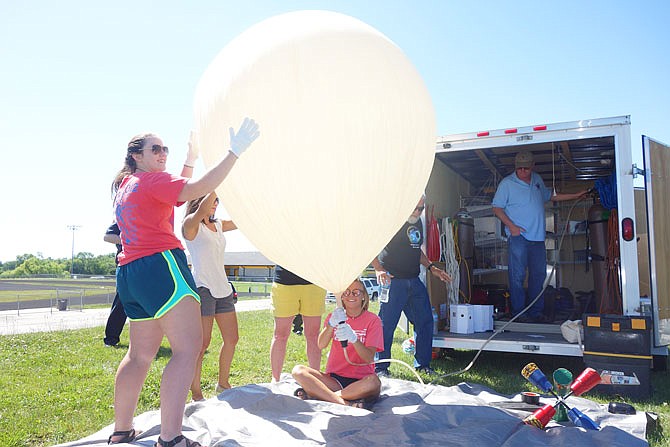 Members of Fulton High School's student council, along with a couple teachers, help inflate a practice weather balloon. Laura Bailey, left, StuCo sponsor and teacher Oly Warner, Haden Trowbridge and Emma Abbott, seated, wore gloves to prevent skin oils from weakening the balloon. Arkansas State University professors J. Tillerman Kennon, second from right, and Ed Roberts supervised the operation.