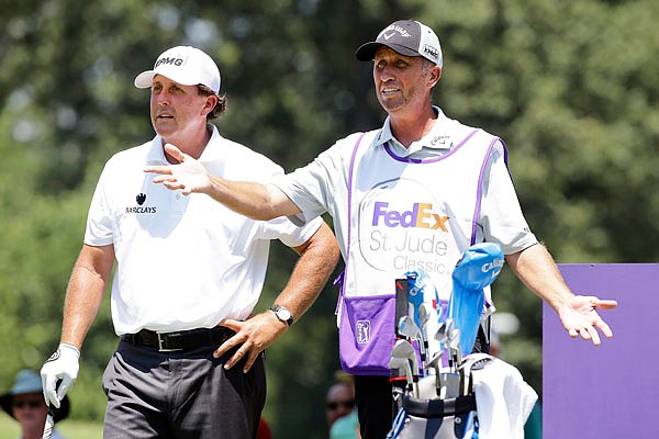 In this June 11, 2015, file photo, Phil Mickelson talks with his caddie Jim Mackay on the tee during the first round of the St. Jude Classic in Memphis, Tenn. Mickelson and his caddie have decided to part ways after 25 years.