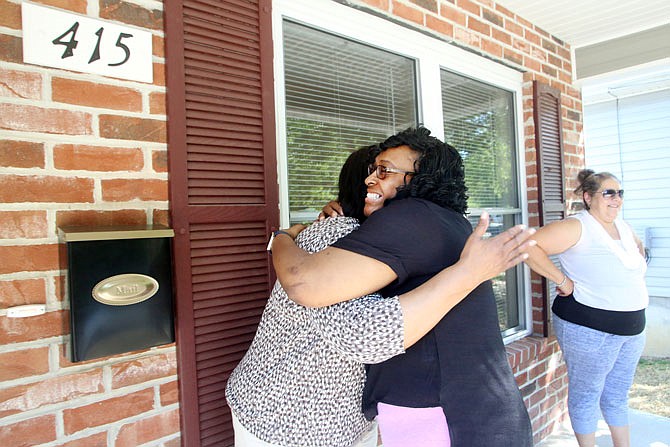 Monica Smith, center, hugs her aunt, Bobbie James, on Wednesday before the blessing of her new home by River City Habitat for Humanity.