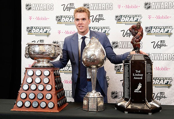 Connor McDavid of the Edmonton Oilers poses with the Art Ross Trophy (left), the Hart Memorial Trophy (center) and the Ted Lindsay Award after winning the honors Wednesday during the NHL Awards in Las Vegas.