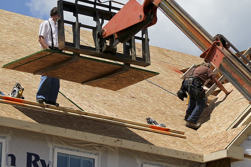 In this Thursday, June 1, 2017, photo, builders work on the roof of a home under construction at a housing plan in Jackson Township, Butler County, Pa. On Friday, June 23, 2017, the Commerce Department reports on sales of new homes in May. (AP Photo/Keith Srakocic)