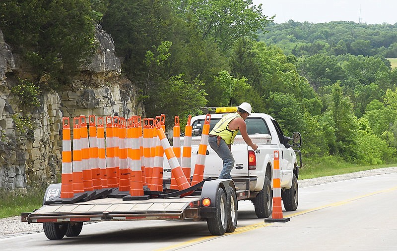 This May 22, 2017 file photo shows a construction crew worker reaching for a traffic cone during work on a Mid-Missouri highway.