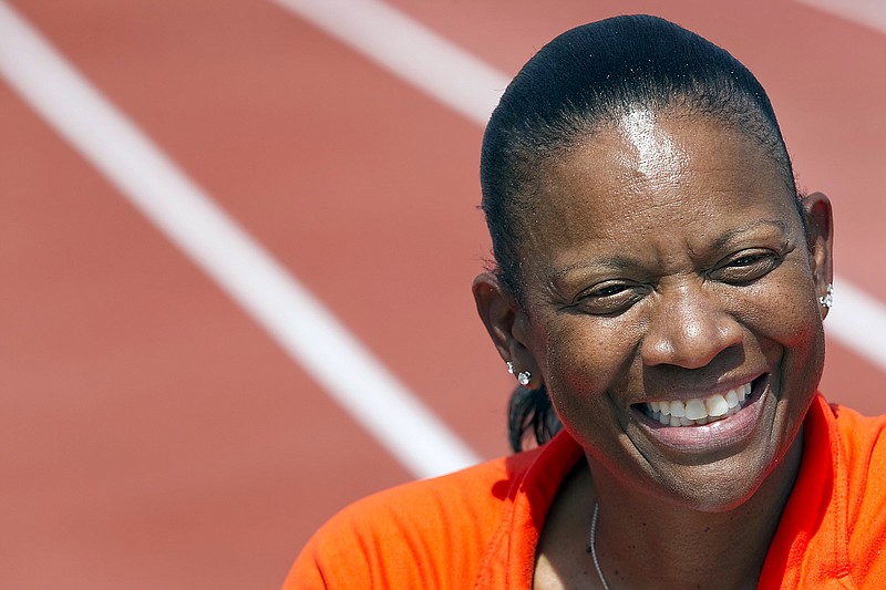 In this March 31, 2011, file photo, Texas women's head track and field coach Beverly Kearney smiles during practice in Austin, Texas. The Texas Supreme Court has refused to block a sex and race discrimination lawsuit filed against the University of Texas by former women's track coach Bev Kearney, who was forced out after the school learned of a romantic relationship with one of her athletes a decade earlier.