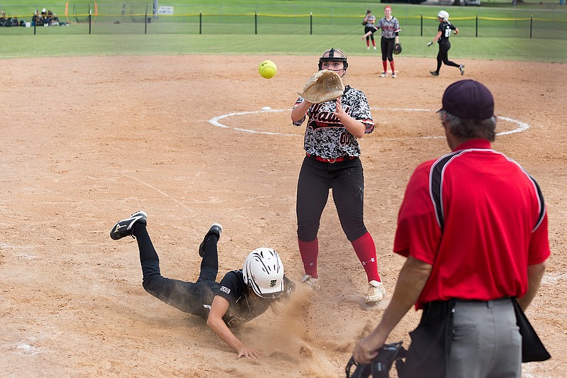 The Texas Slams' Marley Mahoney slides into home as the Hawks' Skylar Wooten attempts to tag her out Saturday at 
Hobo Jungle Park in Texarkana.