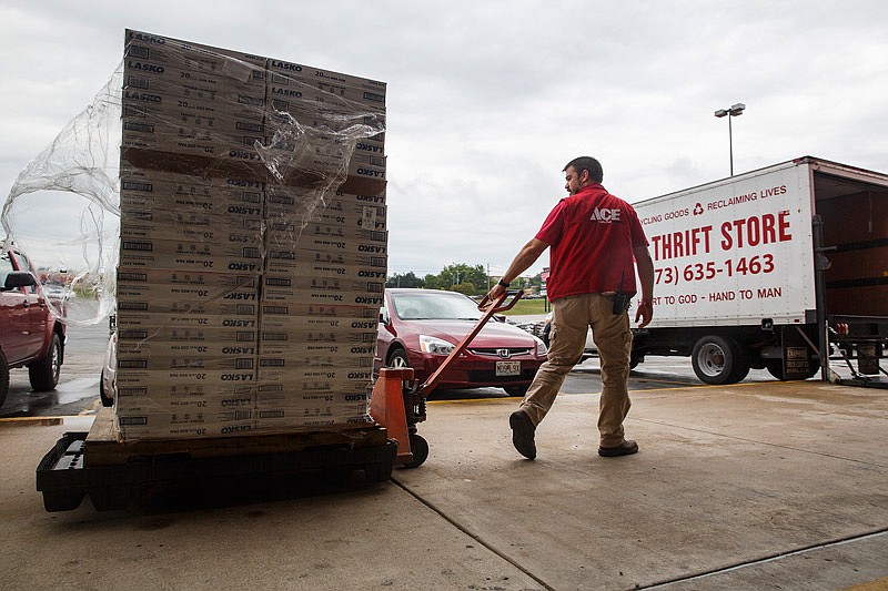 In this Aug. 5, 2015 file photo, Westlake ACE Hardware employee Jason Barton wheels out a stack of box fans that will be given to the Salvation Army to help those in need beat the heat.