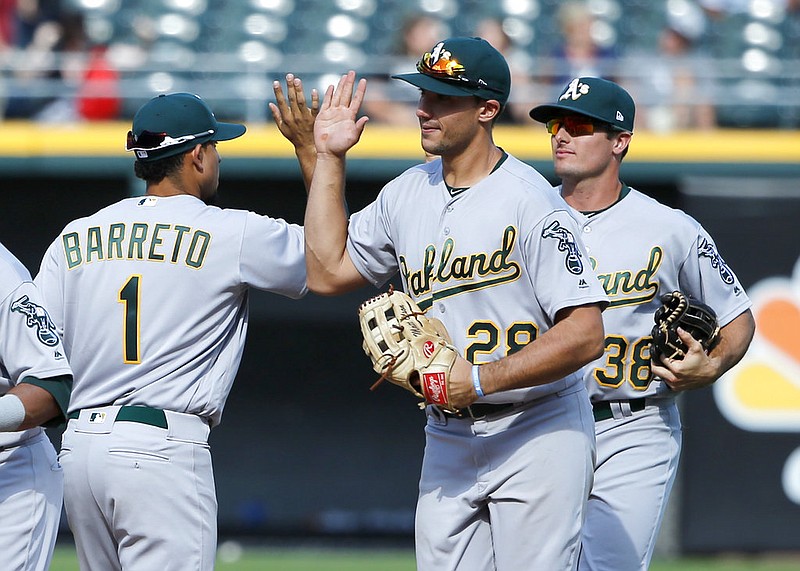 The Oakland Athletics Franklin Barreto (1) Matt Olson, center, and Jaycob Brugman celebrate a win over the Chicago White Sox after a baseball game Saturday, June 24, 2017, in Chicago. 