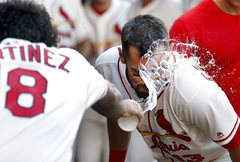 St. Louis Cardinals' Matt Carpenter, right, is congratulated with a cup of water to the face by teammate Carlos Martinez after hitting a solo home run during the first inning of a baseball game against the Pittsburgh Pirates, Saturday, June 24, 2017, in St. Louis. 