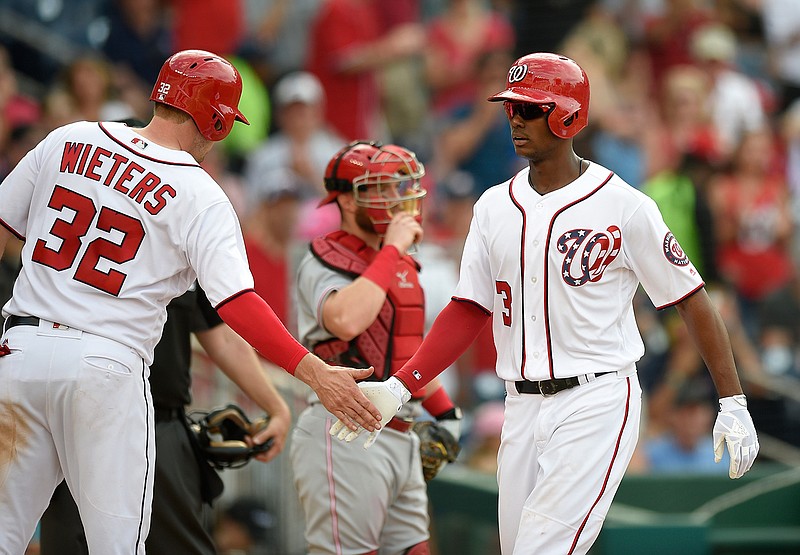 Washington Nationals' Michael Taylor (3) is greeted by Matt Wieters (32) after he hit a two-run home run during the fourth inning of a baseball game as Cincinnati Reds catcher Tucker Barnhart, center, watches Saturday, June 24, 2017, in Washington.